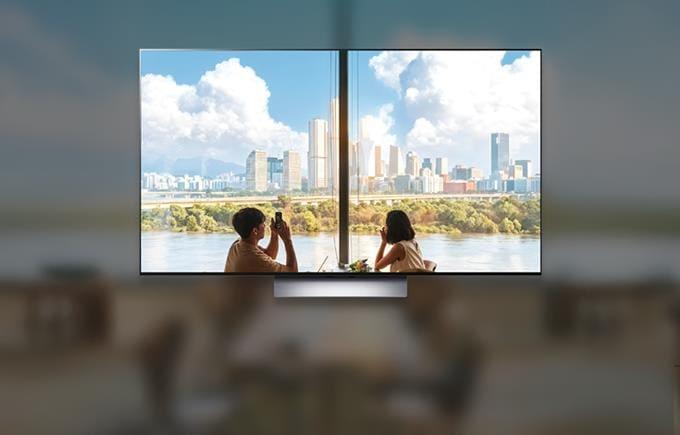 두 남녀가 창밖 풍경을 바라보는 듯한 TV 화면이 중앙에 있다. TV는 도시 풍경과 하늘의 구름을 선명하게 보여줘 올레드 화질을 강조한다.