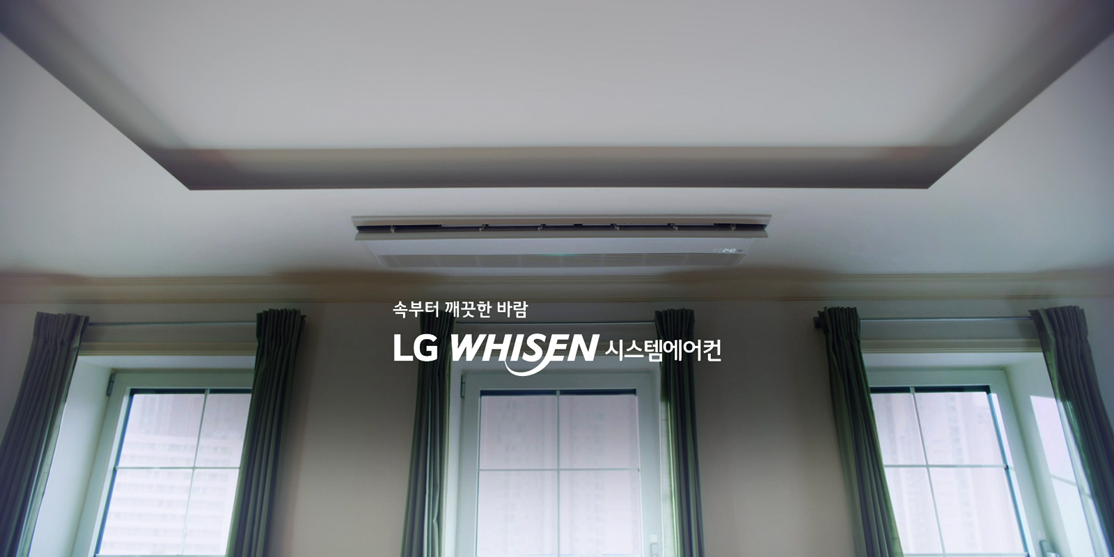 천장에 설치된 에어컨이 보이며, 속부터 깨끗한 바람 LG WHISEN 시스템에어컨이라는 문구가 적혀 있습니다. 창문에는 커튼이 달려 있습니다.
