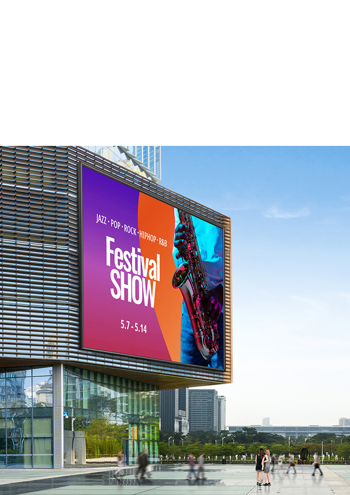 건물 외벽에 대형 전광판이 설치되어 있으며, JAZZ · POP · ROCK · HIPHOP · R&B와 Festival SHOW라는 문구가 적혀 있습니다. 날짜는 5.7 - 5.14로 표시되어 있고, 색색의 배경 위에 색소폰을 연주하는 사람의 이미지가 함께 있습니다. 주변에는 현대적인 고층 건물과 공원이 보이며, 몇몇 사람들이 걷고 있는 모습이 보입니다. 하늘은 맑고 푸릅니다.