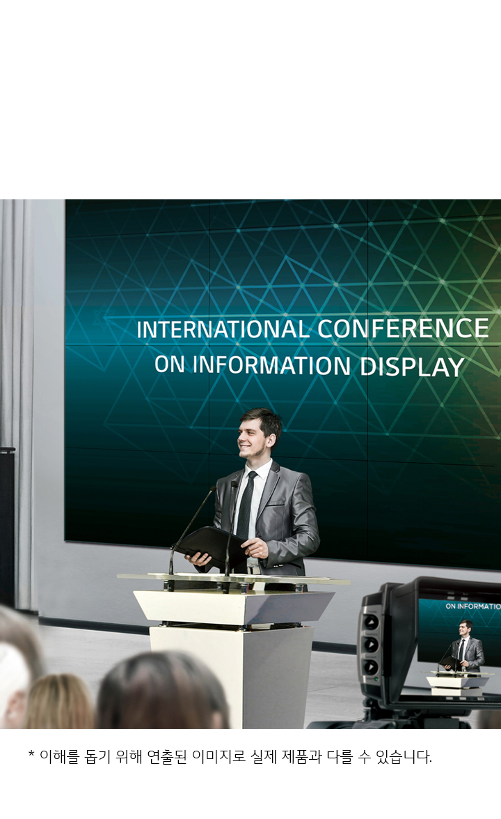한 남성이 연단에서 발표를 하고 있으며, 뒤에는 INTERNATIONAL CONFERENCE ON INFORMATION DISPLAY라는 문구가 있는 대형 스크린이 보입니다. 청중들이 앉아 있는 모습이 보이고, 카메라가 연단의 모습을 촬영하고 있습니다. 이미지 하단에는 화면은 이해를 돕기 위해 연출된 이미지로 실제 제품과 다를 수 있습니다.라는 문구가 있습니다.