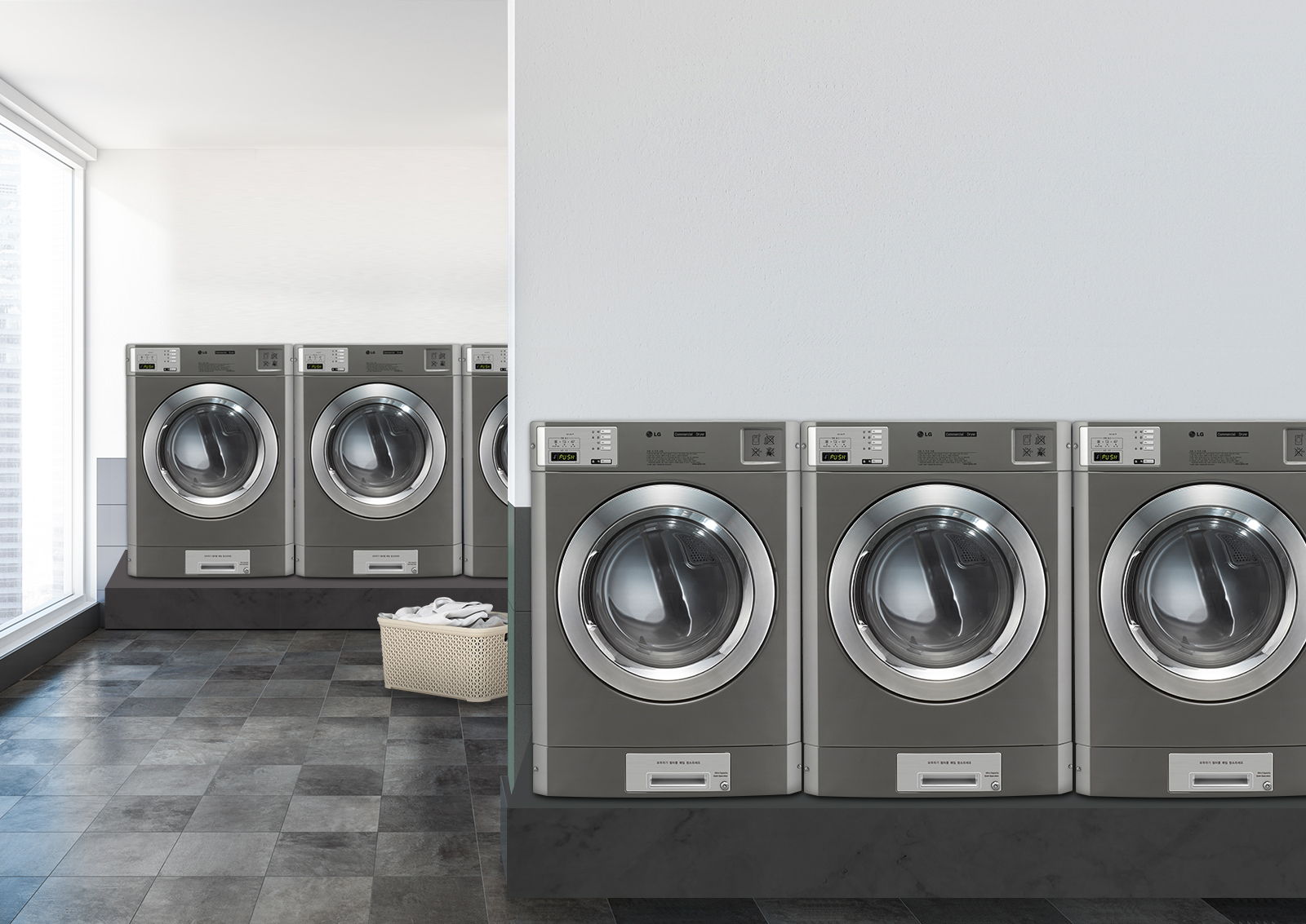 세탁기가 여러 대 놓여 있는 세탁실의 모습입니다. 세탁기 앞에는 빨래 바구니가 놓여 있으며, 바닥은 타일로 되어 있습니다. 세탁기 상단에는 디지털 디스플레이와 조작 버튼이 보입니다. 실내는 밝은 조명으로 환하게 비춰지고 있습니다.