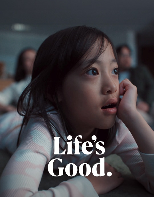 한 소녀가 감탄하는 표정으로 LG 올레드 T를 바라보고 있으며, 이미지 하단 영역에 흰색 텍스트로 Life’s Good.이라고 표기되어 있습니다.
