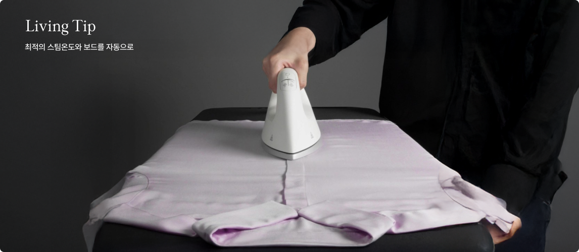 Living Tip 최적의 스팀온도와 보드를 자동으로 문구가 있고, 어두운 회색 배경에서 검은색 상의를 입은 사람이 검은색 다림판 위에 놓인 연보라색 셔츠를 흰색 스팀 다리미로 다림질하고 있는 모습이다.