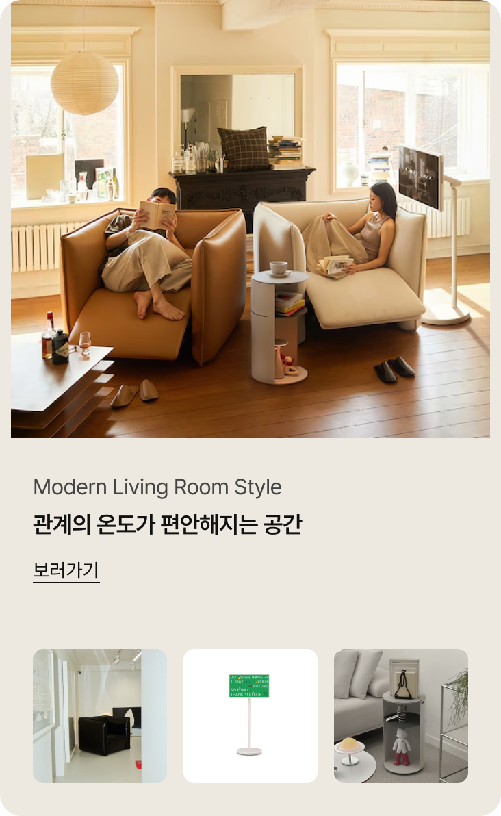 Modern Living Room Style. 관계의 온도가 편안해지는 공간. 상세 이미지 설명: 편안한 휴식을 취할 수 있는 모던한 거실입니다. 두 사람이 각각 브라운과 베이지 색상의 커다란 리클라이너 소파에 깊숙이 앉아 책을 읽거나 휴식을 취하고 있습니다. 소파 사이에는 원형 사이드 테이블이 있고, 우측에는 LG 스탠바이미 TV가 배치되어 있습니다. 배경의 큰 창을 통해 햇살이 들어오며 여유로운 분위기를 자아냅니다.