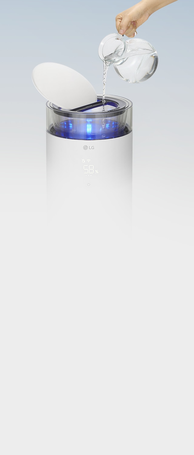 LG 퓨리케어 오브제컬렉션 하이드로에센셜 제품의 상단 부분이 열려 있으며, 한 손이 유리 주전자로 투명한 물통에 물을 보충하고 있는 모습입니다.