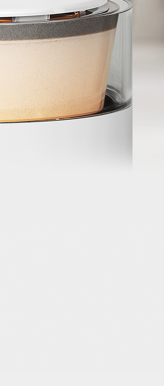 캔들라이트 색상의 조명이 켜져 있는 LG 퓨리케어 오브제컬렉션 하이드로에센셜 제품의 투명한 물통 부분이 확대되어 보이며, 주위에 작은 물방울이 맺혀 있습니다.