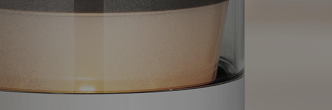 캔들라이트 색상의 조명이 켜져 있는 LG 퓨리케어 오브제컬렉션 하이드로에센셜 제품의 투명한 물통 부분이 확대되어 보이며, 주위에 작은 물방울이 맺혀 있습니다.