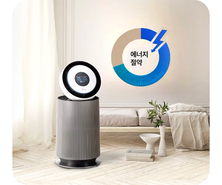 세련된_디자인의_공기청정기가_방_안에_놓여_있으며,_디지털_화면에_10,_14라는_숫자가_표시되어_있습니다._주변에는_커튼이_드리워진_창문과_소파가_보이며,_작은_테이블_위에_책과_화분이_놓여_있습니다._벽에는_에너지_절약이라는_문구와_함께_파란색과_회색으로_구성된_원형_그래프가_그려져_있습니다.