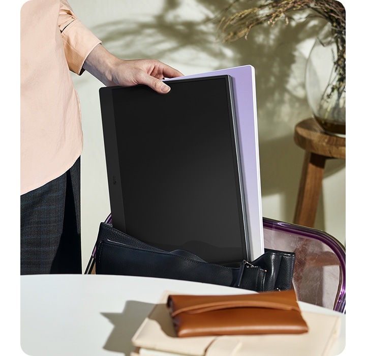 LG 그램 +view를 한손으로 가방에 넣고 있는 모습으로 가벼운 LG 그램 +view를 표현하고 있습니다.