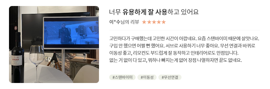 고객 리뷰1 - 리뷰 사진.  너무 유용하게 잘 사용하고 있어요. 이*수님의 리뷰. 별점 5점. 고민하다가 구매했는데 고민한 시간이 아깝네요. 요즘 스탠바이미 때문에 살맛나요. 구입 안 했으면 어쩔 뻔 했어요. 서브로 사용하기 너무 좋아요. 무선 연결과 바퀴로 이동성 좋고, 리모컨도 부드럽게 잘 동작하고 인테리어로도 만점입니다. 없는 거 없이 다 있고, 뭐하나 빠지는게 없어 장점 나열하자면 끝도 없네요. 해시태그. #스탠바이미 #이동성 #무선연결