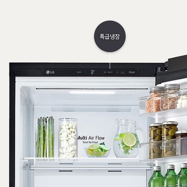 lg_로고가_있는_냉장고_내부_모습이_보입니다._상단에는_특급냉장이라는_텍스트가_있으며,_온도는_3도로_설정되어_있습니다._내부_선반에는_아스파라거스,_잘린_채소,_레몬_슬라이스가_담긴_물병이_있습니다._multi_air_flow_total_no_frost라는_문구가_보입니다._옆_선반에는_다양한_병들이_정렬되어_있습니다.
