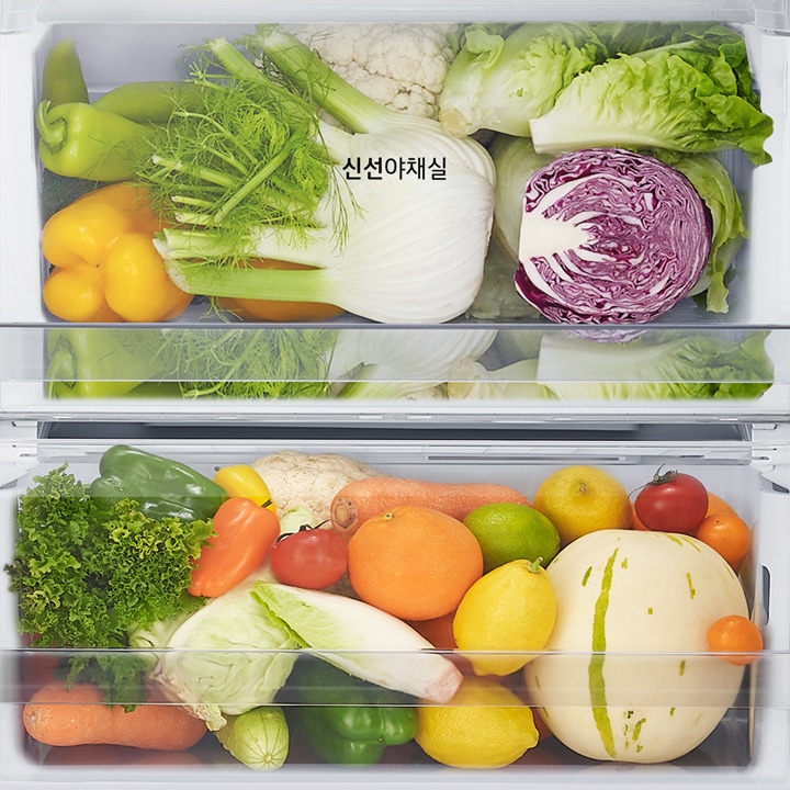 냉장고의_야채_보관실에_다양한_신선한_채소와_과일이_가득_차_있습니다._위쪽_칸에는_양배추,_적양배추,_콜리플라워,_펜넬,_노란색_파프리카가_보이며,_신선야채실이라는_텍스트가_적혀_있습니다._아래쪽_칸에는_상추,_당근,_토마토,_오렌지,_레몬,_라임,_멜론_등이_다양하게_배치되어_있습니다.