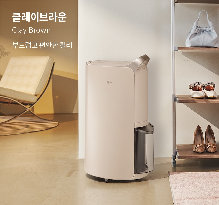 옷방에 설치된 LG 휘센 제습기의 모습입니다. 클레이브라운의 부드럽고 편안한 컬러로 어떤 공간에도 자연스럽게 어우러져 인테리어 효과를 높여줍니다. 깔끔하고 세련된 디자인으로 공간을 더욱 아늑하게 만들어줍니다.