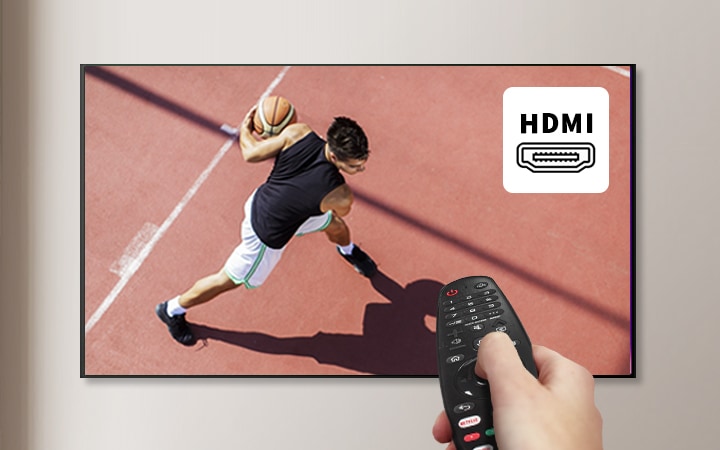 농구_코트를_배경으로_농구공을_들고_있는_사람이_보입니다._화면에_'hdmi'라는_텍스트와_함께_hdmi_포트_아이콘이_표시되어_있습니다._한_손에_리모컨을_들고_있는_모습도_포함되어_있습니다.