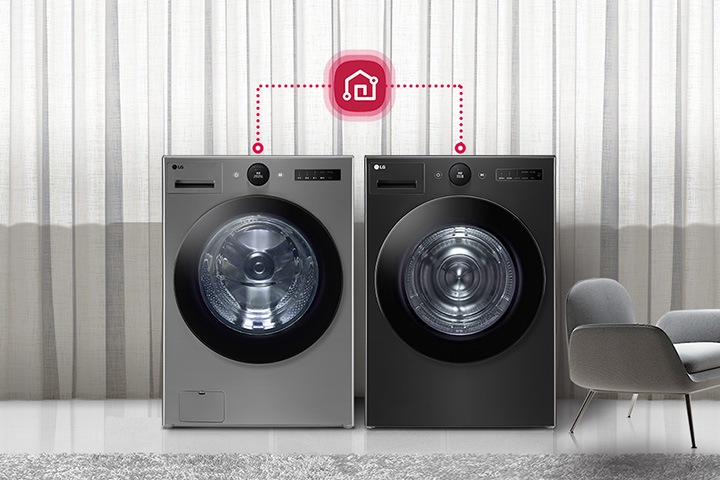 세련된 실내 공간에 두 대의 LG 세탁기가 나란히 놓여 있으며, 그 위에는 스마트홈 연결을 상징하는 아이콘이 점선으로 연결되어 있습니다. 배경은 커튼으로 장식되어 있으며, 세탁기 옆에는 의자와 테이블이 배치되어 있습니다.