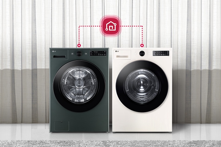 두 대의 LG 세탁기가 나란히 놓여 있으며, 각각의 세탁기 위에는 제어 패널이 있습니다. 세탁기 위에는 스마트 홈 연결을 나타내는 아이콘이 있으며, 점선으로 두 세탁기와 연결되어 있습니다. 배경에는 커튼이 드리워져 있고, 세탁기 옆에는 의자와 테이블이 놓여 있습니다. 테이블 위에는 장식용 꽃병이 있습니다.