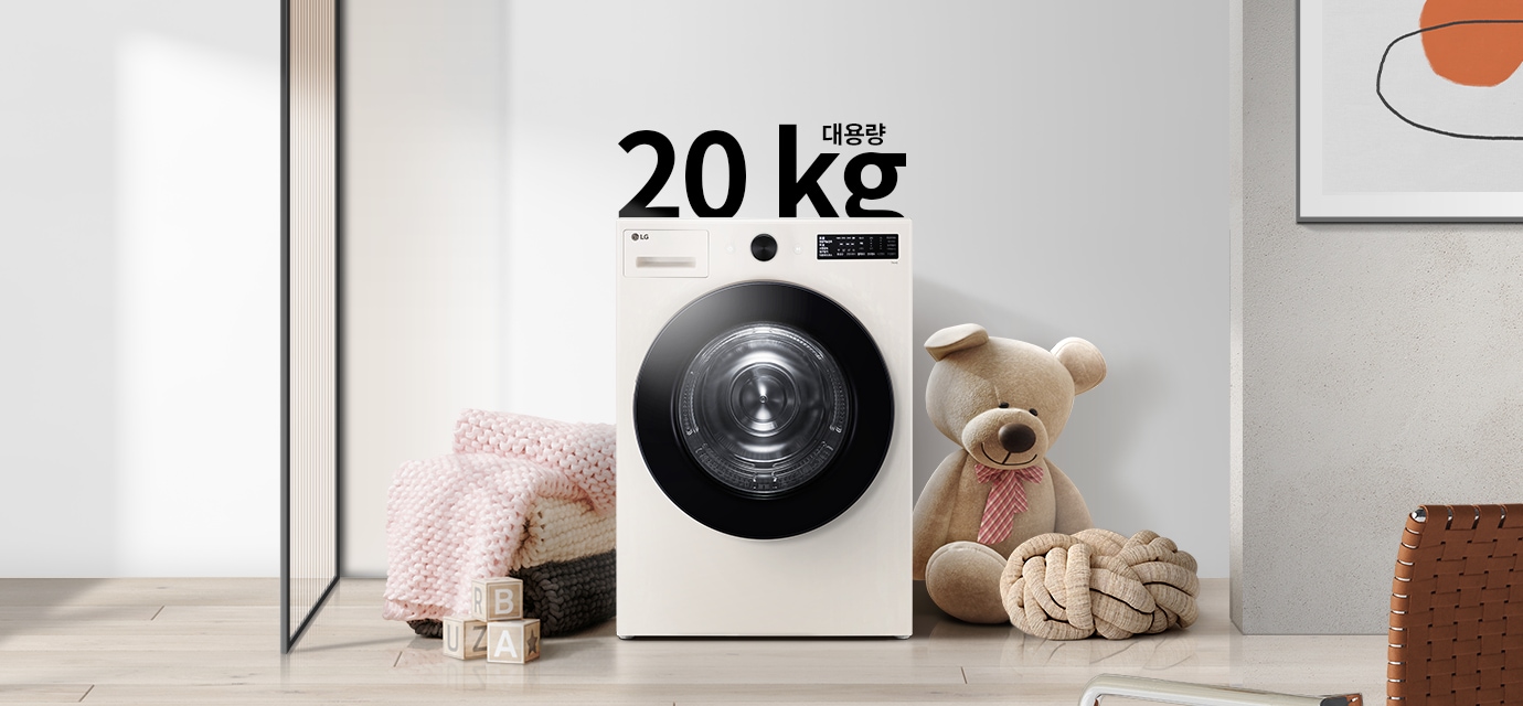 세탁기가 놓여 있으며, 20kg 대용량이라는 텍스트가 있습니다. 세탁기 주변에는 분홍색 담요와 곰 인형이 있고, 바닥에는 알파벳 블록이 놓여 있습니다. 배경은 밝은 색상의 벽과 그림이 걸려 있습니다.