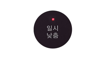 검은색 원 안에 일시 낮춤이라는 흰색 글자가 적혀 있습니다. 원의 상단에는 작은 빨간색 불빛이 보입니다.