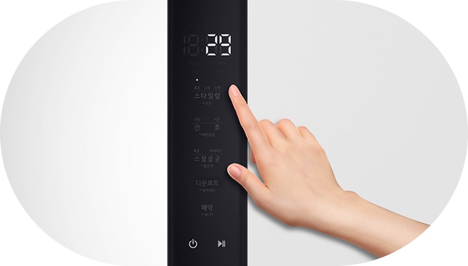 손이_전자_기기의_터치_패널을_조작하고_있습니다._패널에는_스타일링,_건조,_스팀살균,_다운로드_코스,_예약_등의_텍스트가_표시되어_있으며,_화면_상단에는_18:29라는_숫자가_보입니다._전원_버튼과_재생_버튼도_포함되어_있습니다._