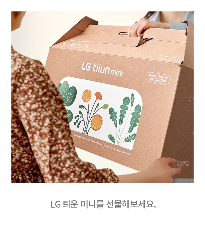 한_사람이_lg_tiiun_mini라고_적힌_상자를_다른_사람에게_건네고_있습니다._상자에는_식물_그림이_그려져_있으며,_better_life_for_all이라는_문구가_보입니다._이미지_아래에는_lg_티운_미니를_선물해보세요.라는_문구가_있습니다.