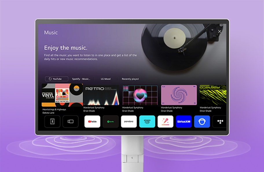 모니터 화면에는 'Music'이라는 제목과 함께 'Enjoy the music.'라는 문구가 있습니다. 'Find all the music you want to listen to in one place and get a list of the daily hits or new music recommendations.'라는 설명이 이어집니다. 화면에는 YouTube, Spotify, LG Mood 등의 옵션이 있으며, 'Recently played' 섹션에는 다양한 앨범 커버 이미지가 나열되어 있습니다. 배경에는 보라색 그라데이션이 사용