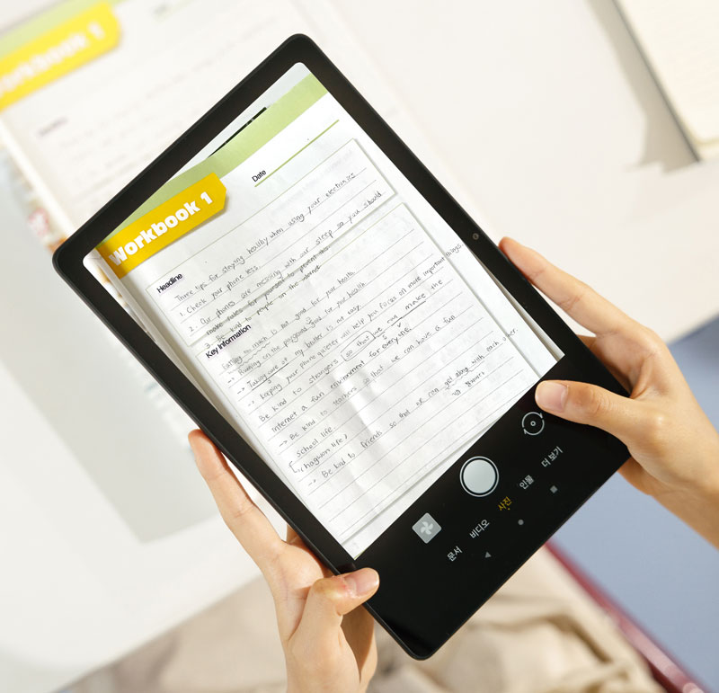 태블릿을_손으로_잡고_있으며,_화면에는_workbook_1이라는_제목의_노트가_보입니다._노트에는_headline,_tips_for_sleeping_easily_when_using_your_electronic_device,_key_information_등의_텍스트가_포함되어_있습니다._태블릿_하단에는_문서,_비디오,_사진,_입력,_더보기_등의_버튼이_있습니다._배경에는_흐릿한_책이_보입니다.