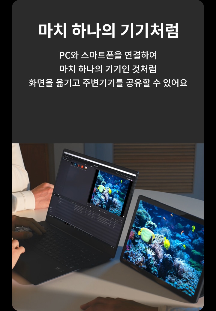 마치 하나의 기기처럼. PC와 스마트폰을 연결하여 마치 하나의 기기인 것처럼 화면을 옮기고 주변기기를 공유할 수 있어요. 두 사람이 테이블에 앉아 노트북과 태블릿을 사용하고 있으며, 두 기기 모두 산호초와 열대어가 있는 바다 사진을 보여주고 있습니다.