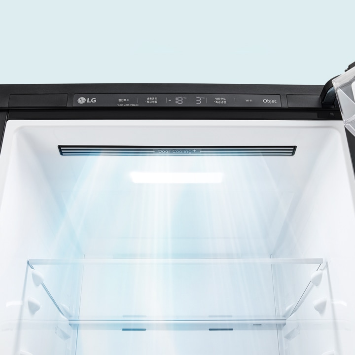 LG 로고가 있는 냉장고의 내부 모습입니다. 상단에는 Door Cooling+라는 텍스트가 보이며, 냉장고 내부에 빛이 비추고 있습니다. 조작 패널에는 냉장고 온도와 관련된 정보가 표시되어 있습니다.