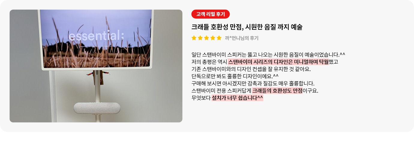 스탠바이미 스피커 제품에 대한 리뷰 컨텐츠입니다. 리뷰 사진에는 스탠바이미 제품과 스피커가 보입니다. 흰색 스탠드 위에 'essential:'이라는 문구가 새겨진 화면이 보이며, 화면 속엔 마른 풀밭 풍경이 담겨 있고 그 아래에는 길고 둥근 베이지색 스피커가 스탠드에 부착되어 있습니다. 배경은 흐릿한 흰색 벽으로, 깔끔하고 미니멀한 인테리어를 보여줍니다. 상세내용은 하단 참고.