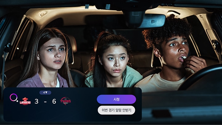 세 명의 젊은이가 자동차 안에 앉아 있으며, 각자 다른 표정을 짓고 있습니다. 화면 하단에는 LANDERS 3 - 6 TWINS라는 점수와 함께 시청 버튼과 이번 경기 알람 안받기라는 텍스트가 포함된 인터페이스가 보입니다.