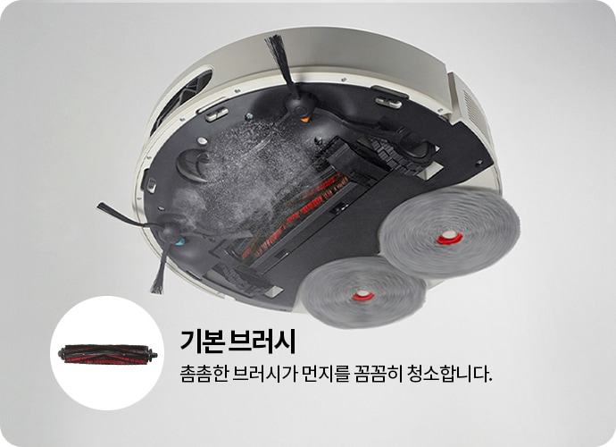 로봇 청소기의 하부 모습이 보이며, 두 개의 회전 브러시와 중앙에 위치한 메인 브러시가 있습니다. 작은 원 안에는 메인 브러시의 확대 이미지가 포함되어 있습니다. 텍스트로 기본 브러시와 촘촘한 브러시가 먼지를 꼼꼼히 청소합니다.라는 설명이 있습니다.