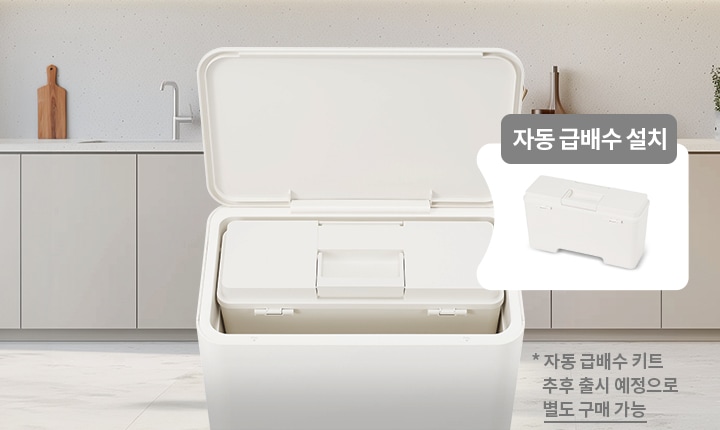 뚜껑이 열린 흰색 용기가 있으며, 용기 안에는 자동 급배수 설치가 가능한 장치가 보입니다. 배경에는 주방 조리대와 싱크대가 있습니다. 텍스트로는 자동 급배수 설치와 * 자동 급배수 키트 추후 출시 예정으로 별도 구매 가능이 포함되어 있습니다.