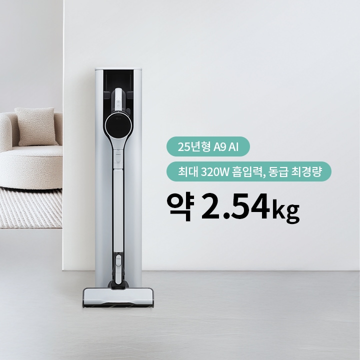 세련된 디자인의 진공 청소기가 벽에 세워져 있으며, 옆에는 둥근 소파와 쿠션이 놓여 있습니다. 소파 앞에는 작은 테이블이 있습니다. 이미지에는 25년형 A9 AI 최대 320W 흡입력, 동급 최경량 약 2.54kg라는 문구가 포함되어 있습니다.