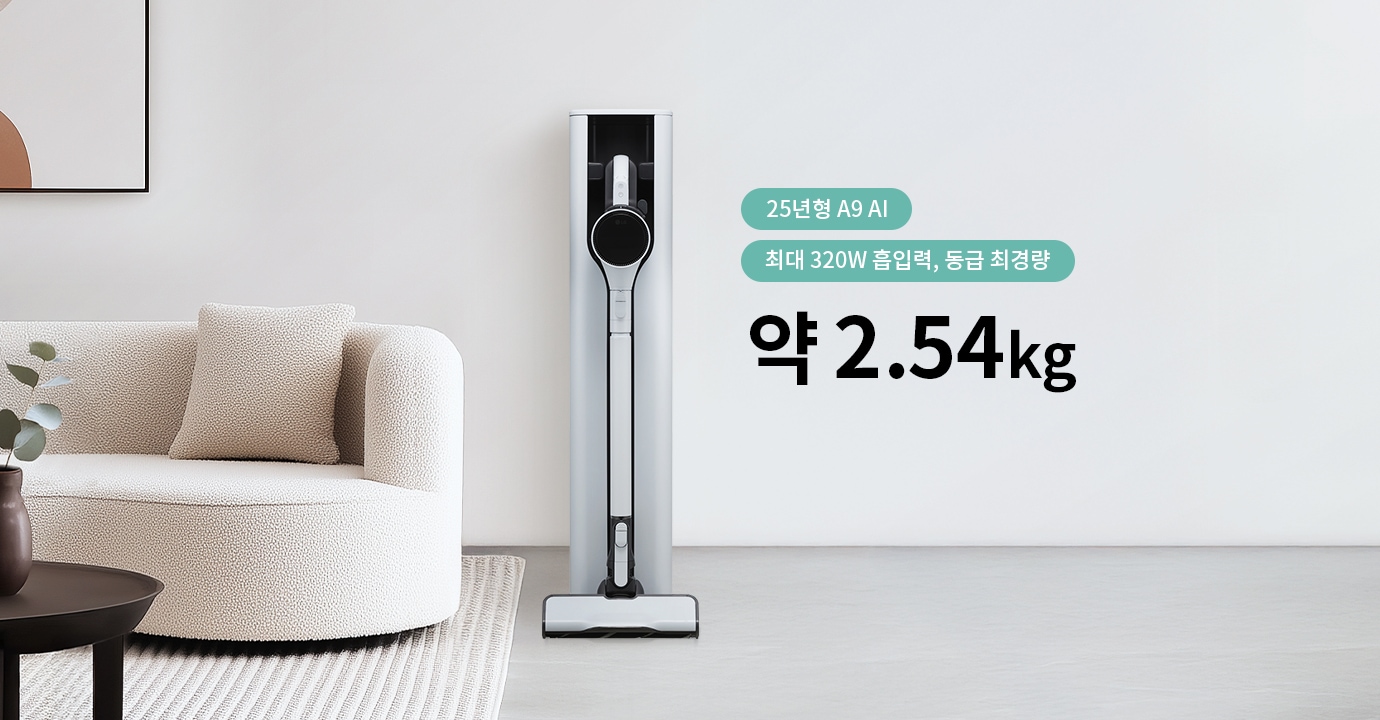 세련된 디자인의 진공 청소기가 벽에 세워져 있으며, 옆에는 둥근 소파와 쿠션이 놓여 있습니다. 소파 앞에는 작은 테이블이 있습니다. 이미지에는 25년형 A9 AI 최대 320W 흡입력, 동급 최경량 약 2.54kg라는 문구가 포함되어 있습니다.