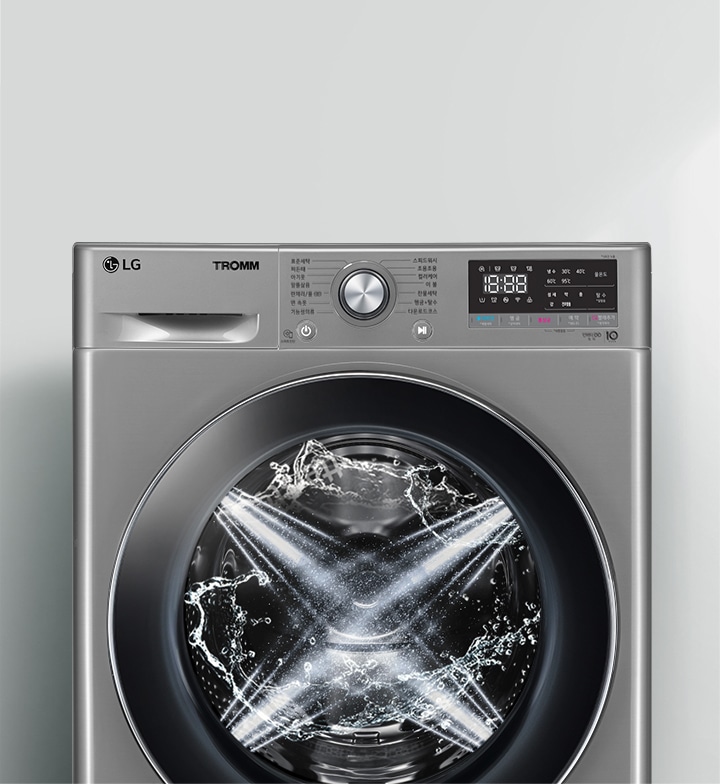 LG 트롬 세탁기가 보입니다. 세탁기 문 안쪽에는 물이 회전하며 세탁이 진행 중인 모습이 보입니다. 세탁기 상단에는 다양한 세탁 모드와 설정을 위한 다이얼과 디지털 디스플레이가 있습니다. 디스플레이에는 시간과 여러 설정 옵션이 표시되어 있습니다. 