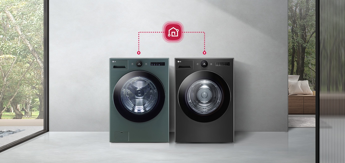 흰색과 검은색 세탁기가 나란히 놓여 있으며, 위쪽에 스마트홈 아이콘이 연결된 모습입니다. 배경으로는 큰 창문을 통해 나무가 보이고, 실내에는 소파와 쿠션이 있습니다. 세탁기에는 LG와 AI DD라는 텍스트가 표시되어 있습니다.