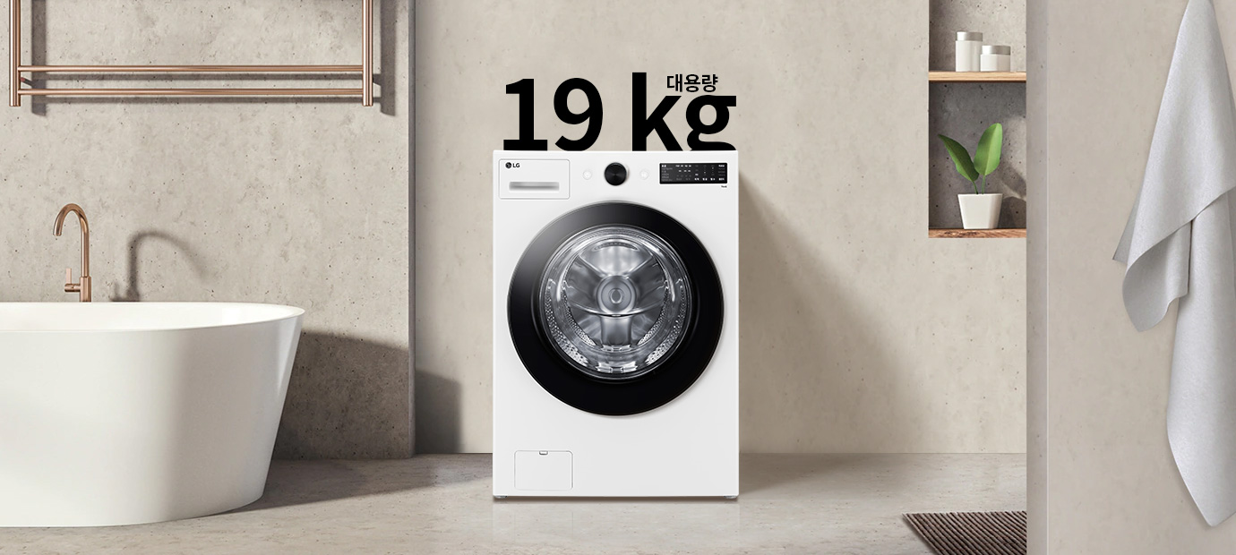 세탁기가 욕실에 놓여 있으며, 세탁기 위에는 19 kg 대용량이라는 텍스트가 있습니다. 세탁기 옆에는 욕조와 수건이 걸려 있고, 벽 선반에는 화분과 용기가 놓여 있습니다.
