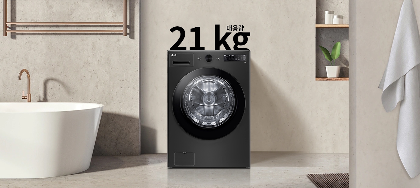 세탁기가 욕실에 놓여 있으며, 세탁기 위에는 21kg 대용량이라는 글자가 있습니다. 욕조와 수건이 걸려 있고, 선반에는 화분과 용기가 놓여 있습니다. 전체적으로 깔끔하고 현대적인 인테리어가 돋보입니다.