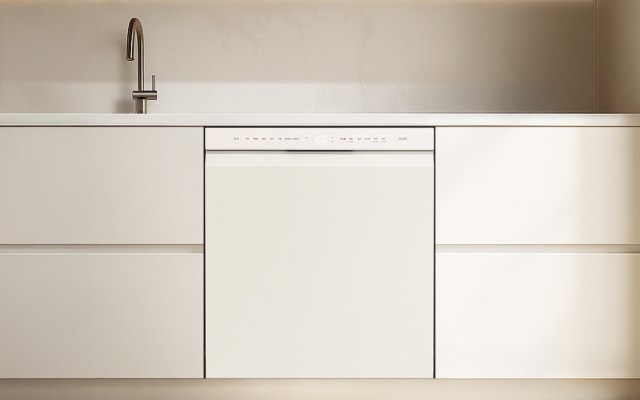 미니멀한 디자인의 주방으로, 크림색 수납장과 빌트인 식기세척기, 그리고 싱크대 수전이 보이는 공간입니다.