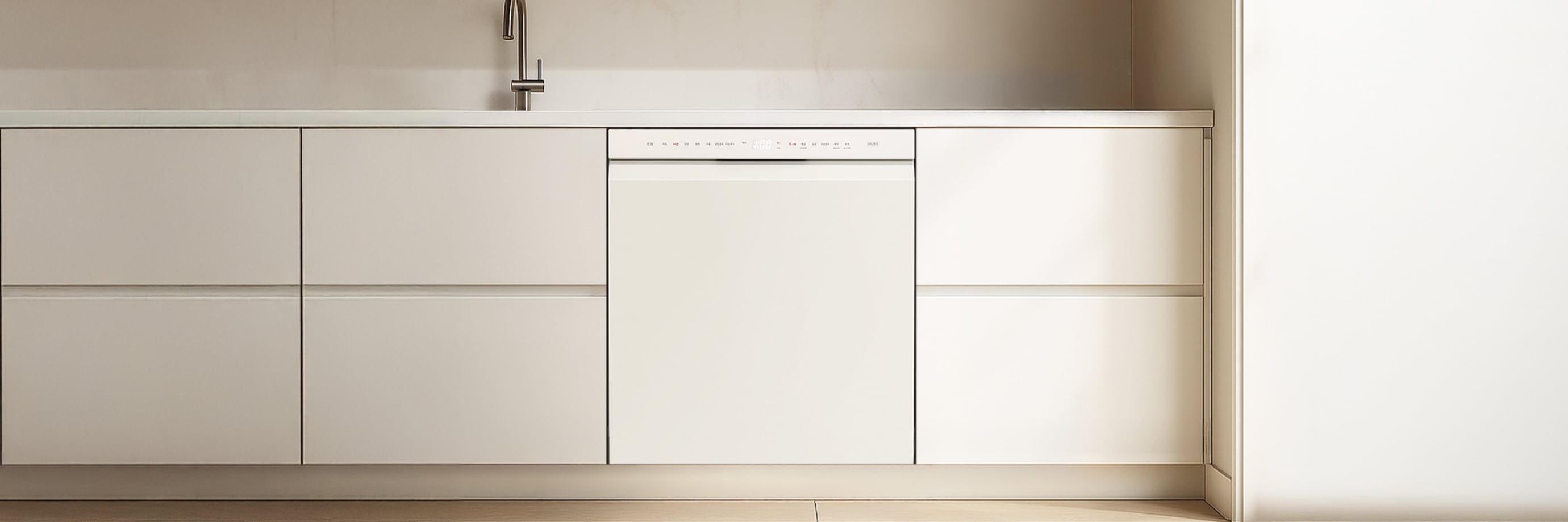 미니멀한 디자인의 주방으로, 크림색 수납장과 빌트인 식기세척기, 그리고 싱크대 수전이 보이는 공간입니다.