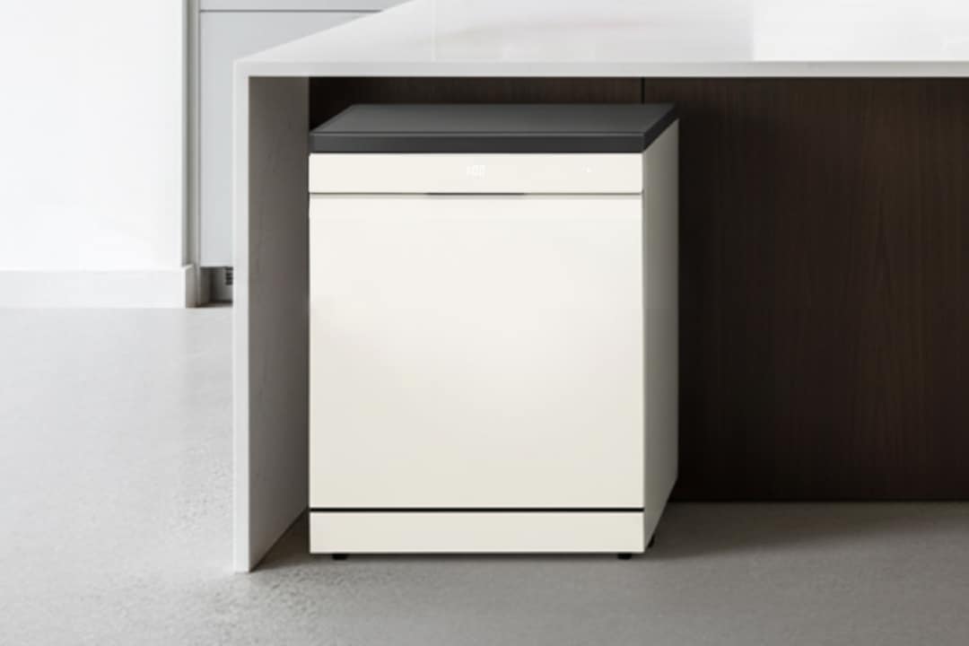 화이트 컬러의 프리스탠딩 식기세척기가 흰색 조리대 아래에 설치되어 있으며, 검은색 상판과 디지털 디스플레이가 장착되어 있습니다.