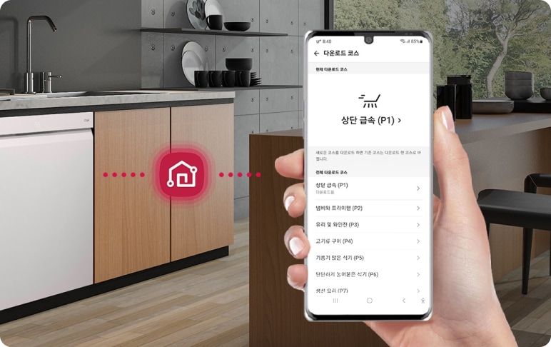 주방에는 나무 소재의 캐비닛과 가스레인지가 설치되어 있으며, 그 옆에는 식기세척기가 있습니다. 식기세척기 앞에는 스마트홈 아이콘이 표시되어 있습니다. 한 손이 스마트폰을 들고 있으며, 화면에는 '다운로드 코스'라는 제목과 함께 '상단 급속 (P1)', '냄비와 프라이팬 (P2)', '유리 및 와인잔 (P3)', '고기류 구이 (P4)', '기름기 많은 식기 (P5)', '단단하게 눌어붙은 식기 (P6)', '쌓서 요리 (P7)' 등의 옵션이 나열되어 있습니다. 배경에는 식기와 창밖의 나무가 보입니다.