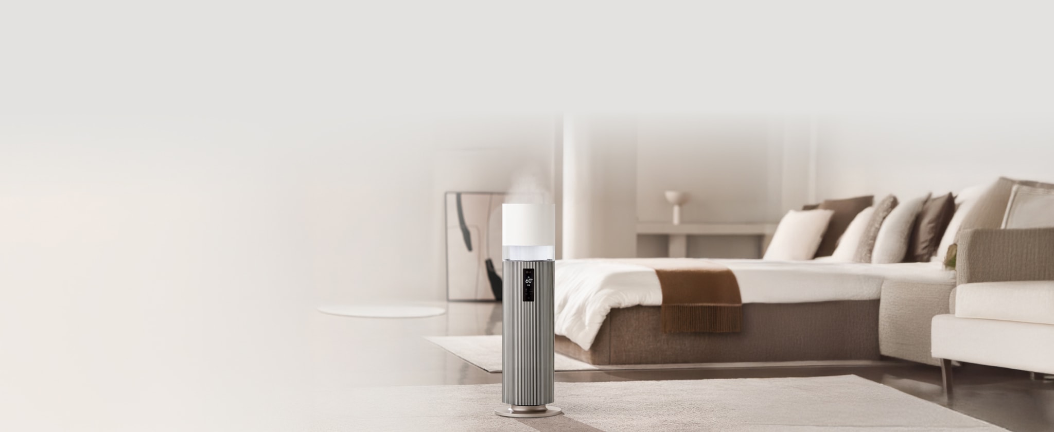 밝은색 거실에 놓인 LG 퓨리케어 하이드로타워 가습기로, 상단에서 미세한 수증기가 분사되고 있고, 전면 패널에 디지털 화면이 표시되어 있습니다. 배경에는 벽난로와 장작 더미, 흰색 소파와 쿠션, 세로 줄무늬 나무 벽면이 보입니다.