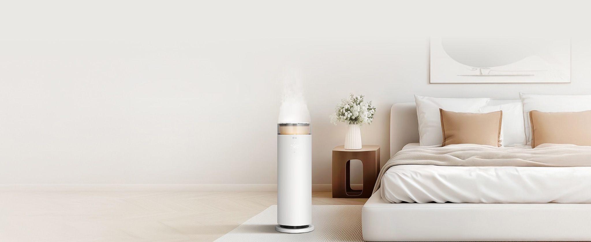 침실에 위치한 LG 퓨리케어 하이드로에센셜 가습기로, 상단에서 미세한 수증기가 분사되고 있습니다. 침대 옆 협탁에는 흰색 꽃병에 담긴 꽃이 장식되어 있으며, 침대는 흰색 침구로 깔끔하게 정리되어 있습니다. 바닥에는 흰색과 회색 줄무늬가 있는 러그가 깔려 있어 전체적으로 차분하고 깨끗한 분위기를 연출하고 있습니다.
