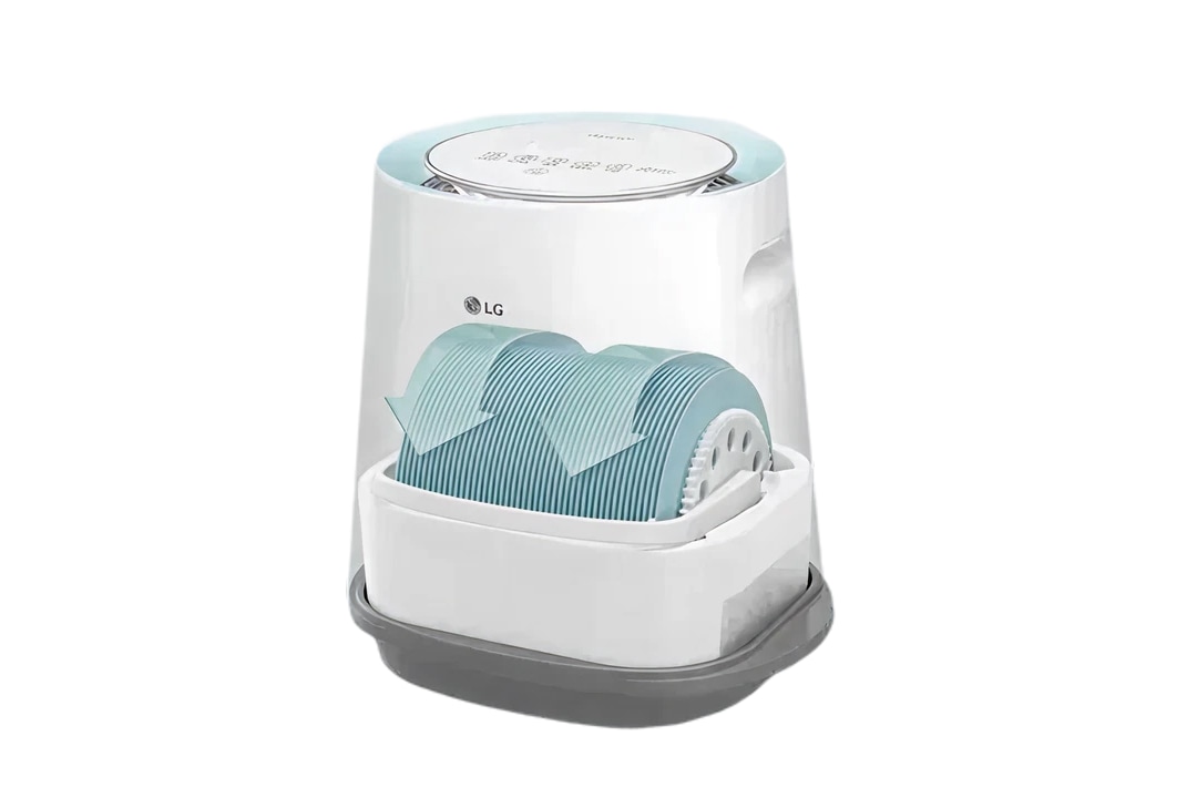 LG 로고가 있는 가습기 이미지입니다. 상단에는 여러 개의 버튼이 있으며, 필터 부분이 보입니다. 필터에는 화살표가 그려져 있습니다. 전체적으로 흰색과 회색, 하늘색이 조화를 이루고 있습니다.