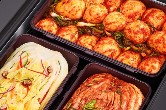 김치냉장고 용기 안에 총각김치, 백김치, 배추김치가 각각 정갈하게 담겨 있으며, 선명한 색감과 재료의 신선함이 유지되고 있습니다.