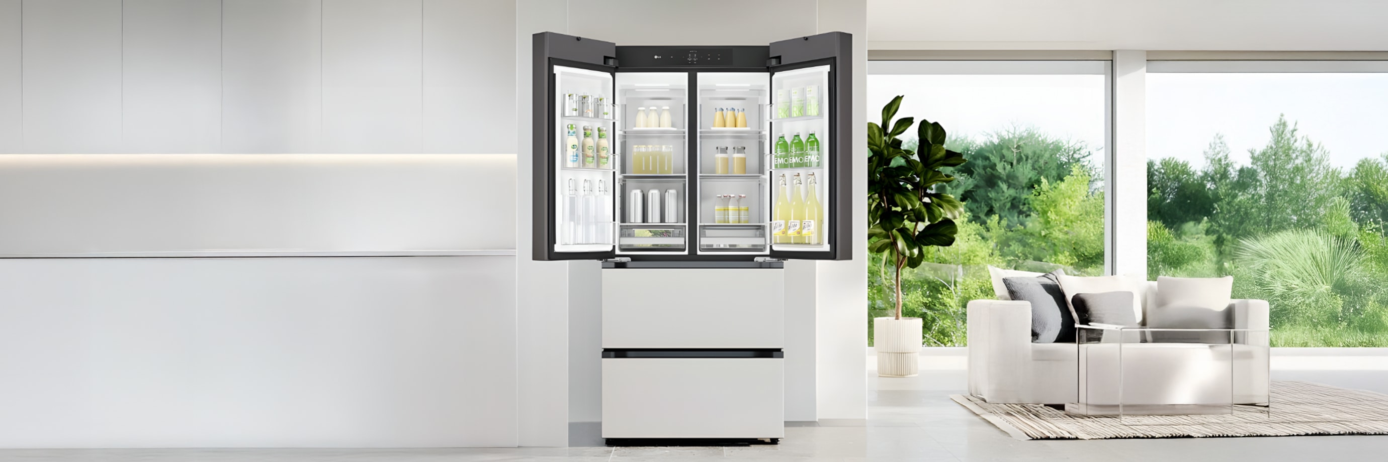 중앙에는 도어가 활짝 열린 매트 화이트 프렌치도어 김치냉장고가 설치되어 있습니다. 냉장고 내부에는 각종 음료와 유제품이 정돈되어 있으며, 투명한 선반 구조로 내용물이 한눈에 잘 보이도록 구성되어 있습니다. 오른쪽에는 초록 식물과 함께 자연 풍경이 보이는 대형 창이 있어 공간 전체에 밝고 탁 트인 분위기를 더합니다.
