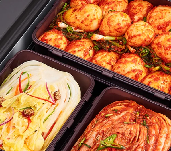 김치냉장고 용기 안에 총각김치, 백김치, 배추김치가 각각 정갈하게 담겨 있으며, 선명한 색감과 재료의 신선함이 유지되고 있습니다.