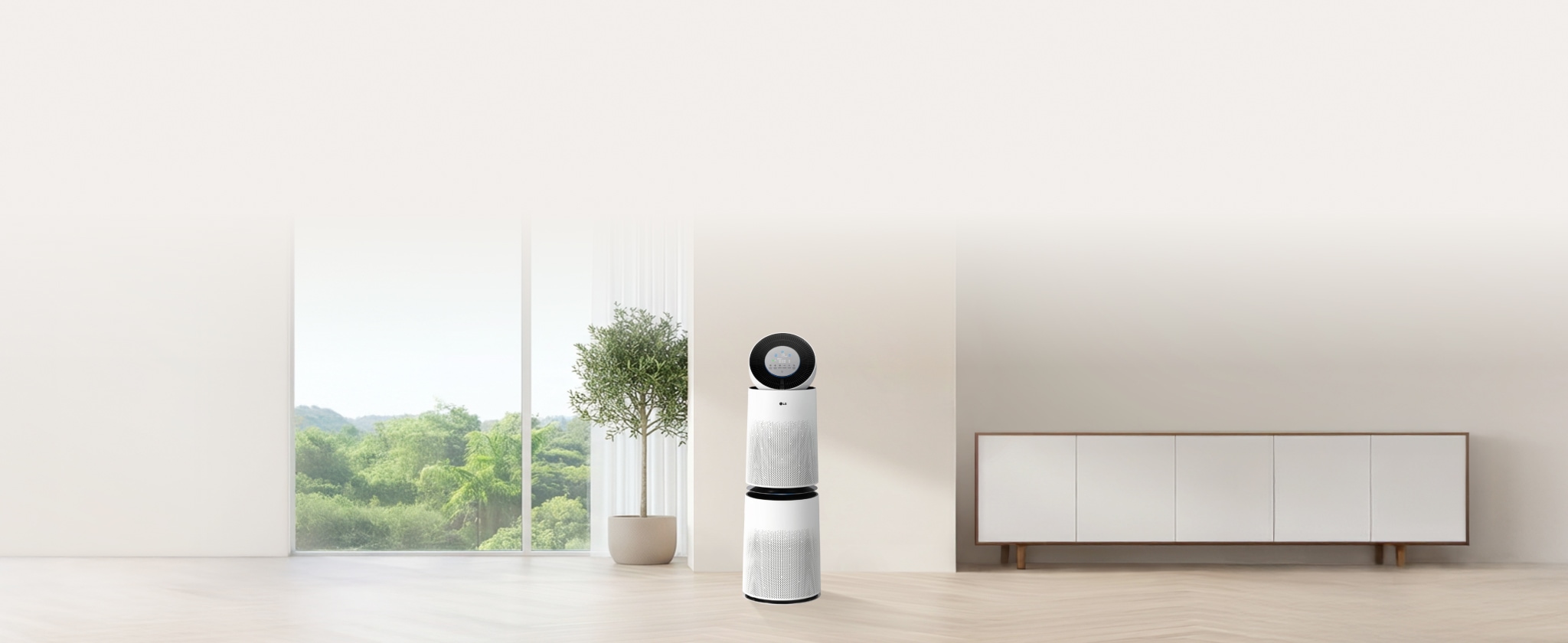 밝은 거실 공간에 놓인 LG 퓨리케어 AI 360˚ 공기청정기 플러스의 모습입니다. 공기청정기는 검은색 원형 상단부와 흰색 원통형 몸체 두 개로 구성되어 있으며, 현대적이고 세련된 디자인을 강조합니다.