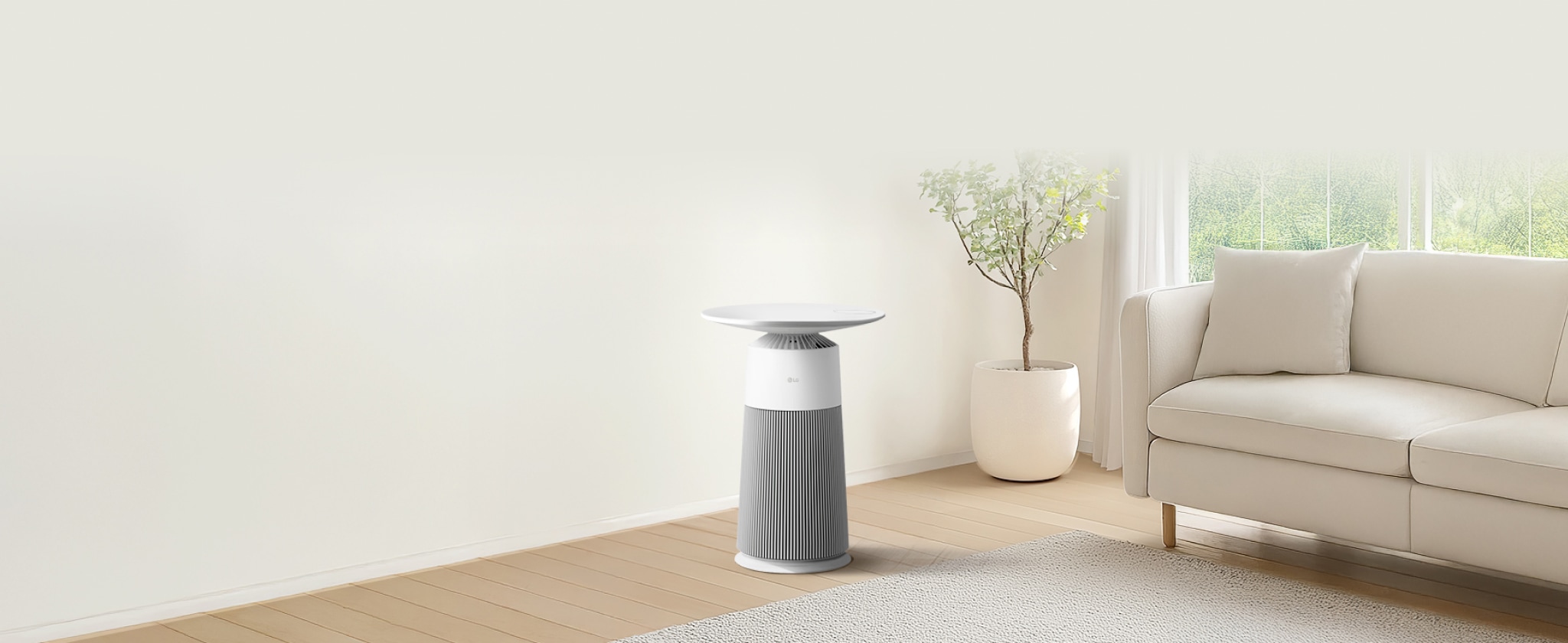 하얀 배경의 거실 환경에 LG 퓨리케어 AI 오브제컬렉션 에어로퍼니처 제품이 배치되어 있습니다. 공기청정기 원통형 본체는 수직으로 배열된 얇은 회색 선으로 디자인이 되어 있으며, 상단에는 흰색 원형 테이블이 결합되어 있습니다. 바닥에는 흰색과 파란색이 조합된 디자인의 러그가 있습니다.